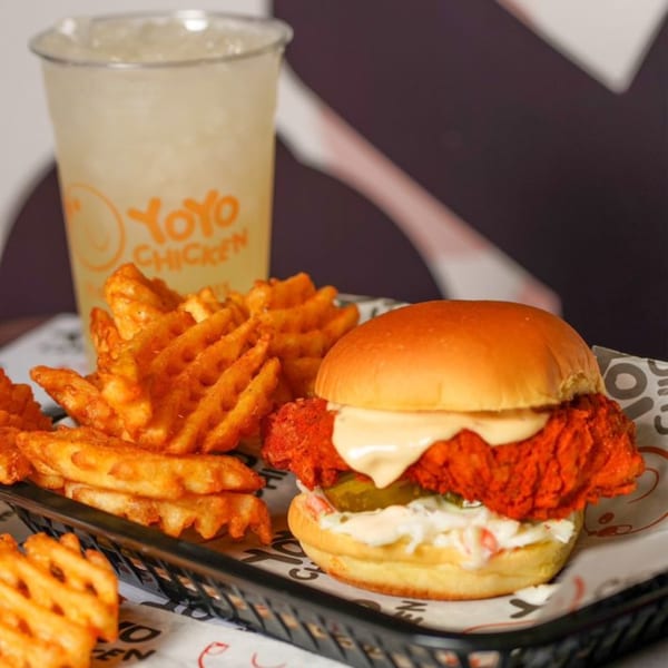 Yoyo Chicken's fried chicken sandwich with waffle fries and a branded drink.