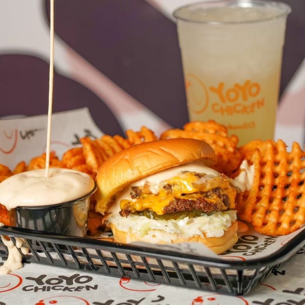Yoyo Chicken's double cheeseburger with waffle fries, dipping sauce, and a drink.