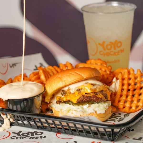 Yoyo Chicken burger with waffle fries, dipping sauce, and a drink with the Yoyo Chicken logo.
