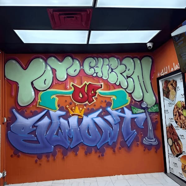 Graffiti art on an orange wall with "Yoyo Chicken" in green and "of Elliott" in purple.